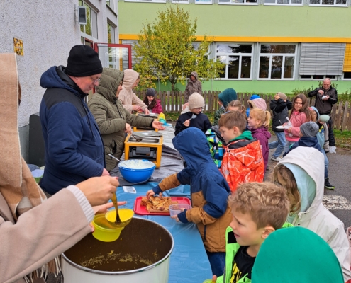Am Freitag vor den Herbstferien feierte die Eichendorffschule ihr traditionelles Kartoffelfest. Die Viertklässler hatten in den Wochen zuvor fleißig Kartoffeln geerntet und gereinigt. Gemeinsam mit ihren Lehrerinnen und Lehrern zauberten die Drittklässler dann an diesem Freitag köstliche Gerichte für alle Grundschüler. Die Schüler schnippelten, kochten und rührten mit großer Begeisterung. Es gab knusprige Wedges mit Quark, Bratkartoffeln, Kürbissuppe und – passend zur Saison – leckeren Zwetschgenkuchen. In der 5. Stunde versammelten sich alle auf dem Pausenhof, wo viele Eltern, Großeltern und Freunde ebenfalls erschienen, um gemeinsam zu feiern. Der Hof war lebhaft gefüllt, die Töpfe leerten sich rasch, und niemand musste hungrig nach Hause gehen. Neben den köstlichen Speisen bot die Garten-AG auch selbstgemachte Produkte aus dem Schulgarten zum Verkauf an: Marmelade, Sirup, Ringelblumensalbe und Tee. Der Erlös fließt in neue Gartengeräte.